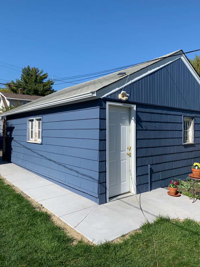 Small building painted navy blue after painting